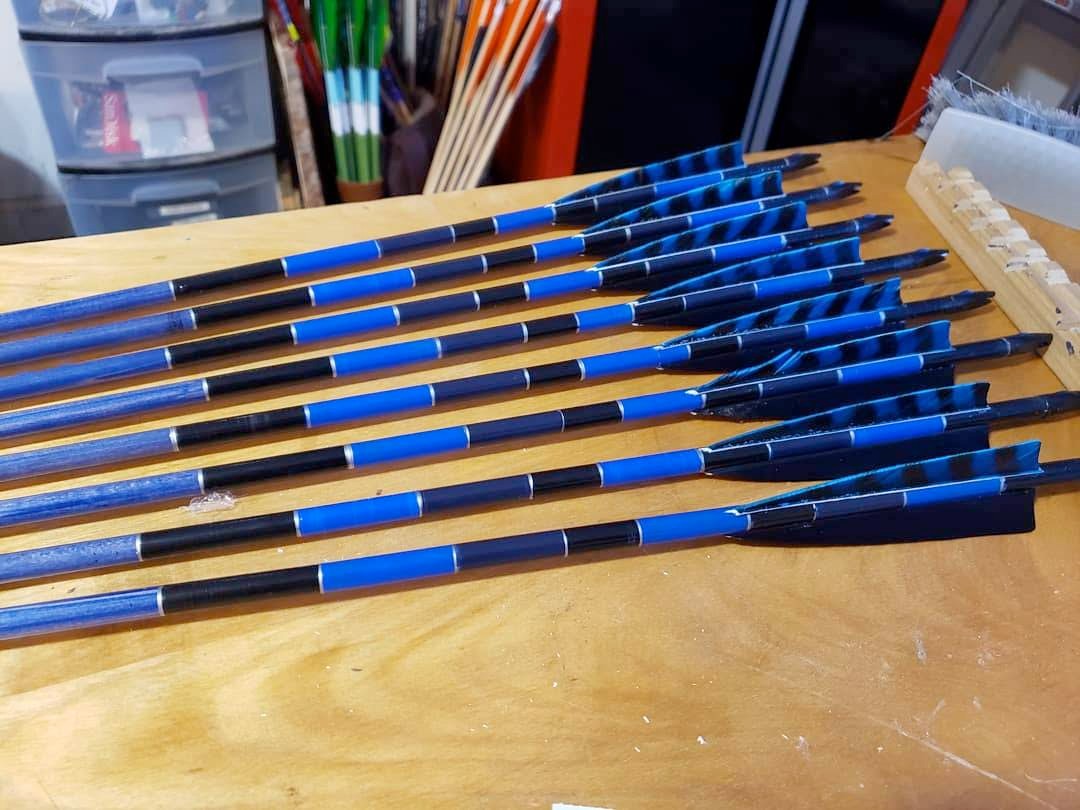 Blue and black fletched arrows on the workbench