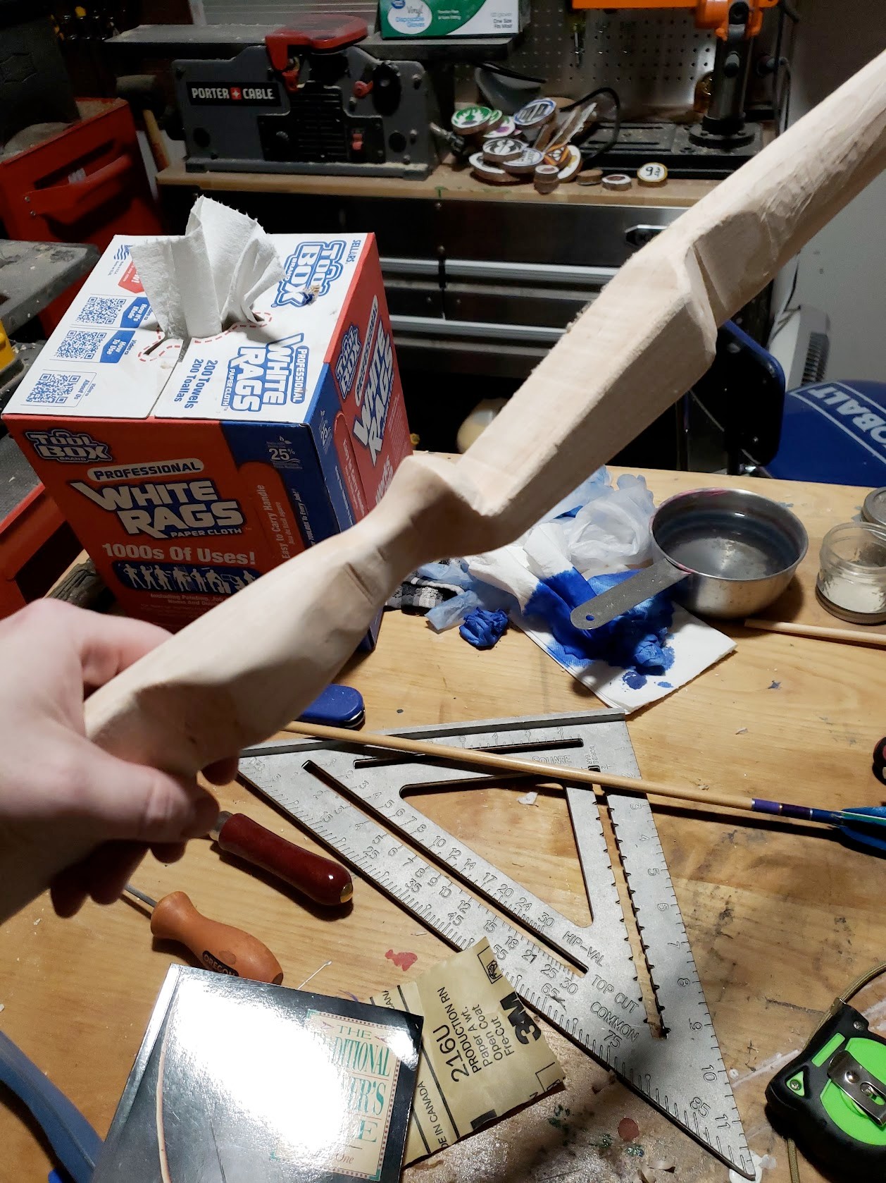 Hand-carved bow riser in progress at the workbench