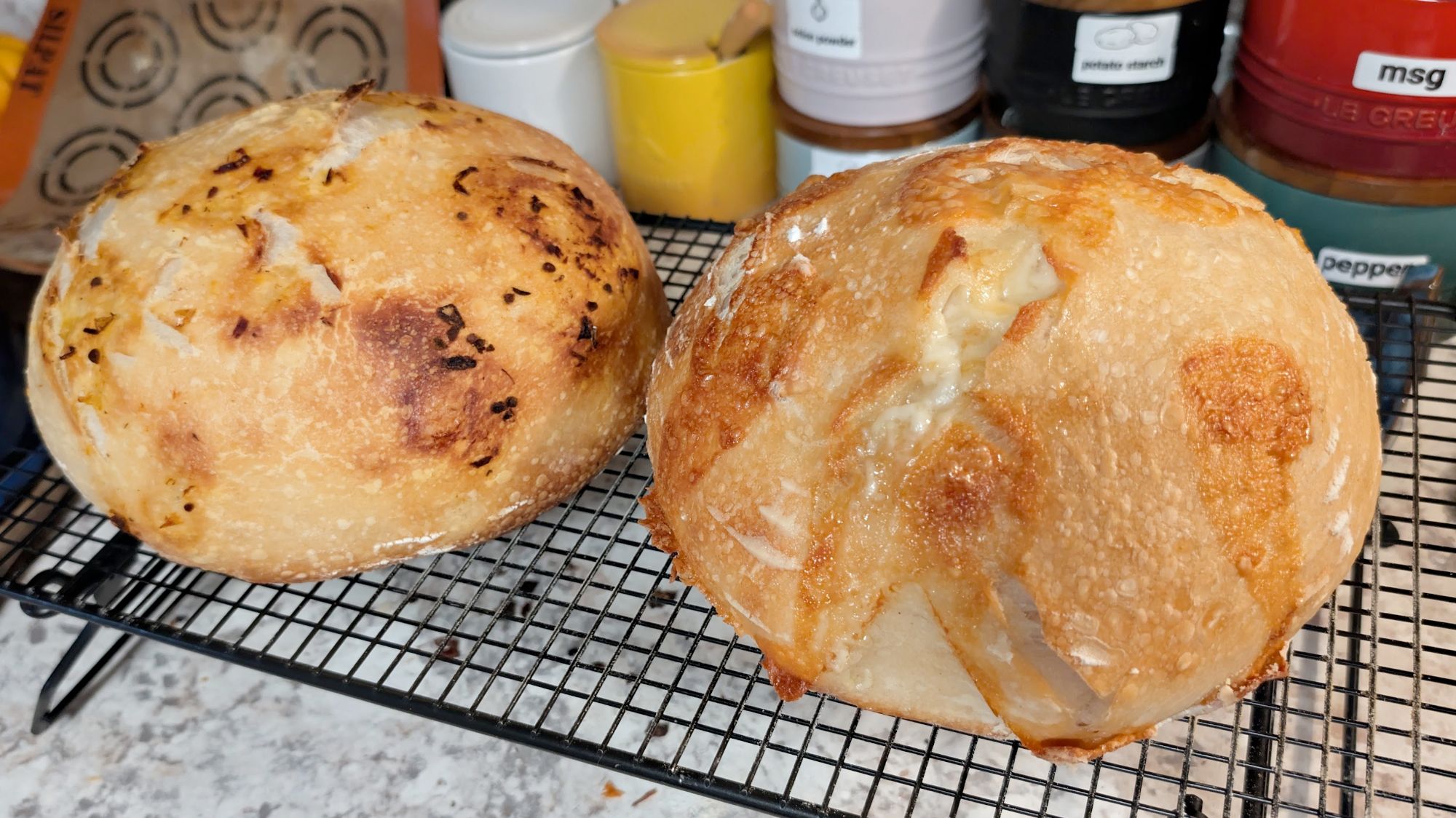Two golden sourdough boules cooling on a wire rack